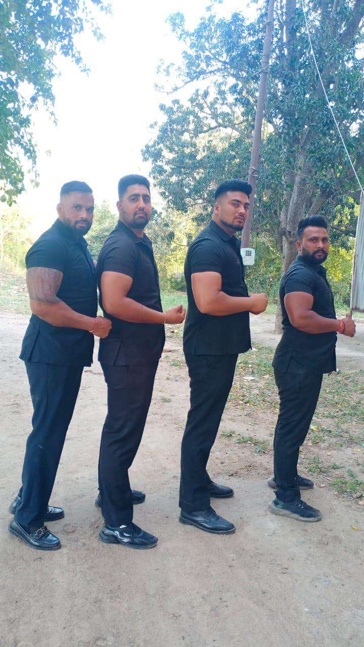four bouncers posing in black uniform